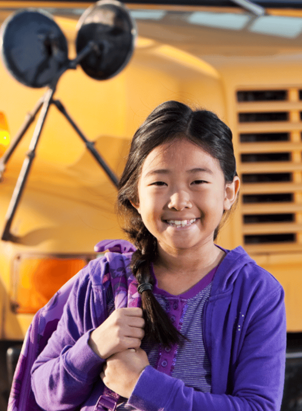 Smiling child in front of school bus with wifi