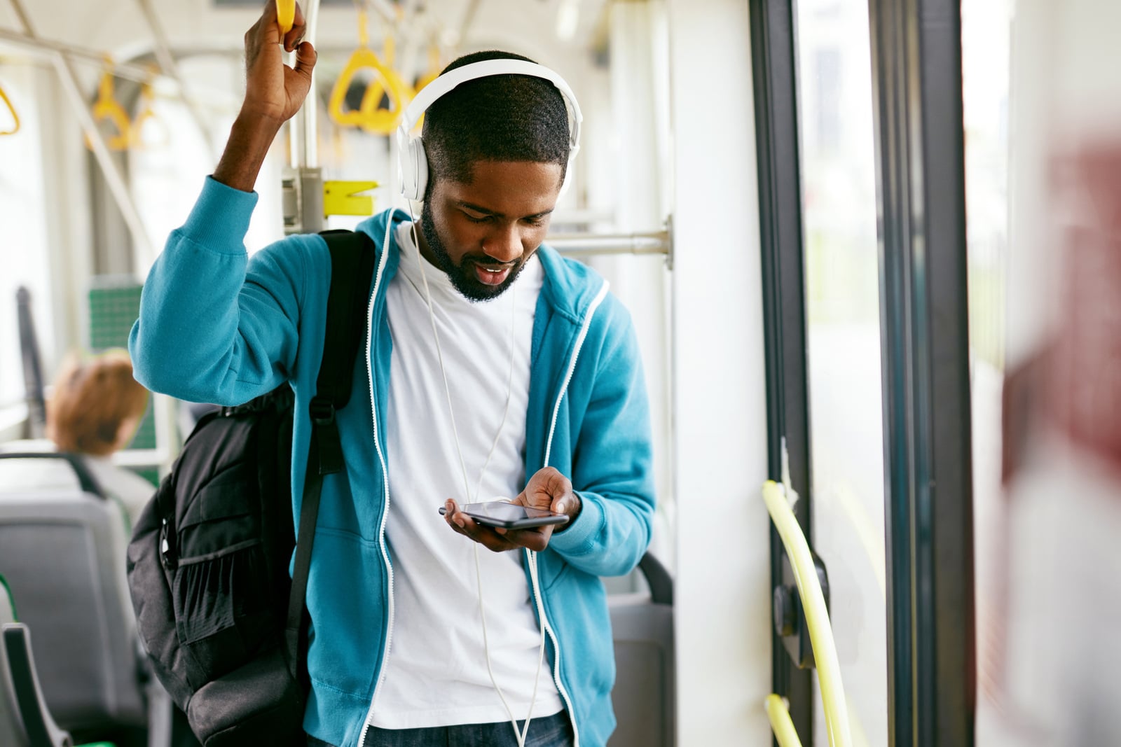 Rider on transit bus with phone connected to Wi-Fi - photo