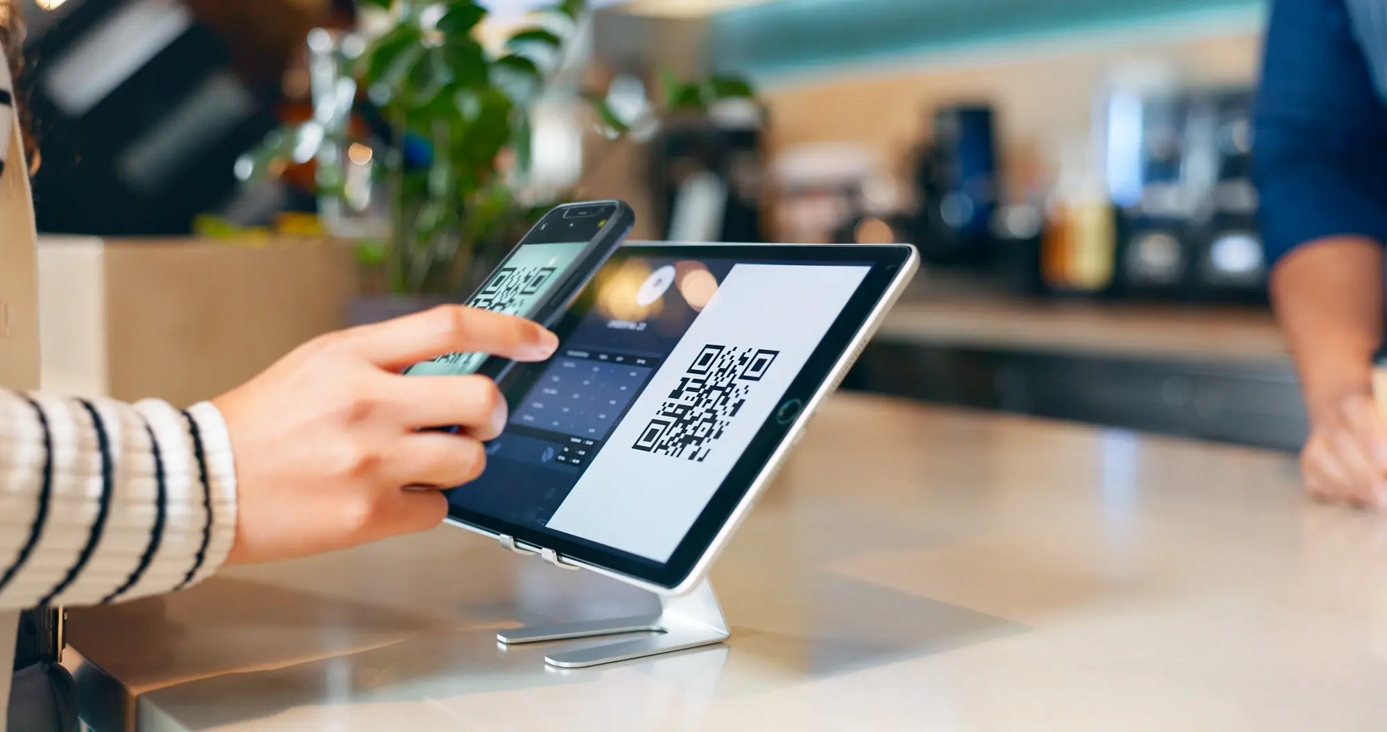 Customer paying via QR code at wireless POS terminal - photo