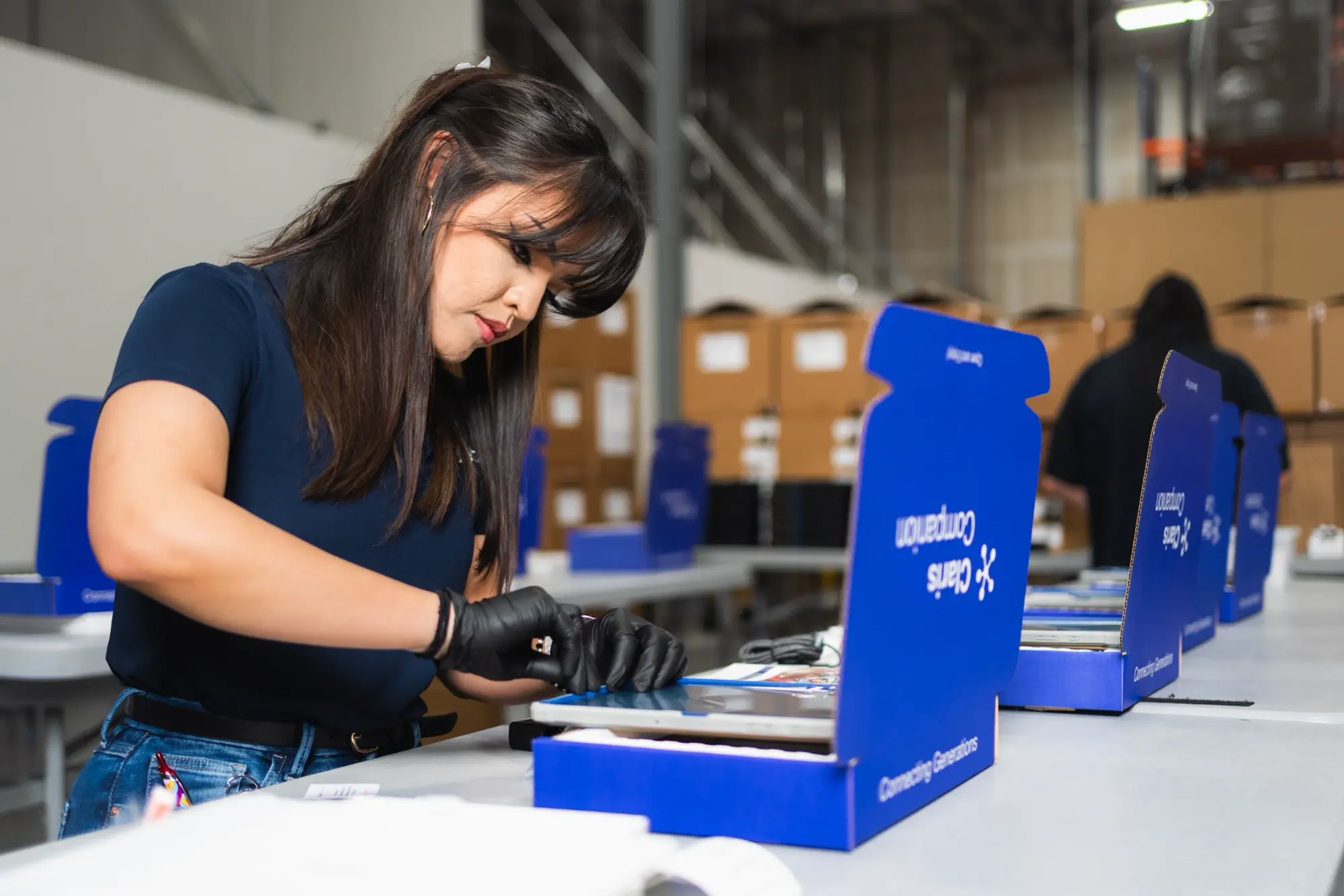 Kajeet technician kitting Claris telehealth device in warehouse - photo