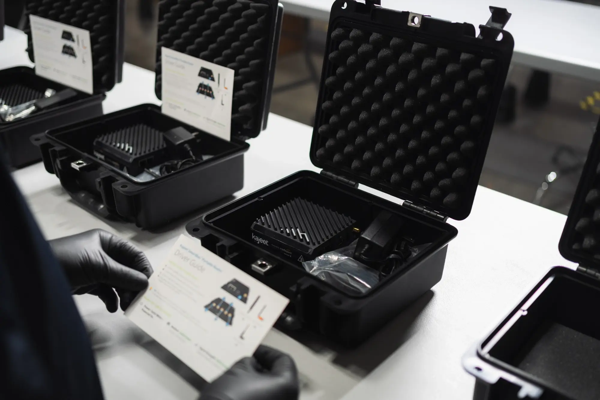 Kajeet connectivity technician kitting mobile Wi-Fi routers in warehouse - photo