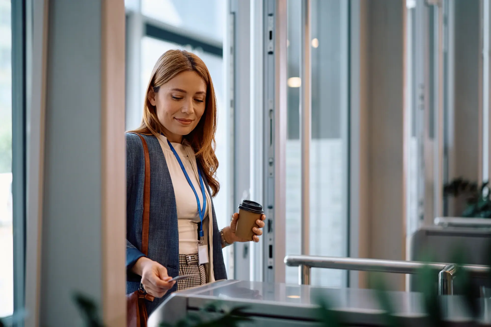 Woman scanning keycard at wireless security terminal - photo